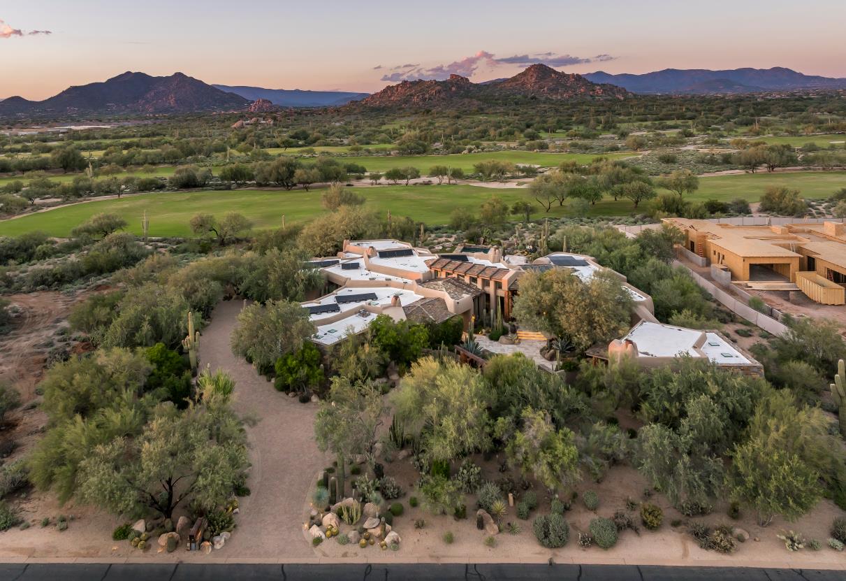 Warm evening light across the residence, golf course and mountains.