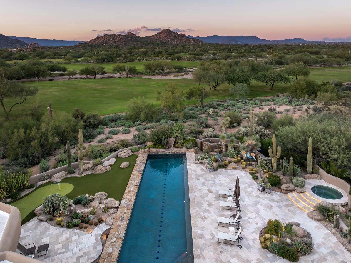 An elevated view along the lap pool toward the golf course and mountain backdrop.