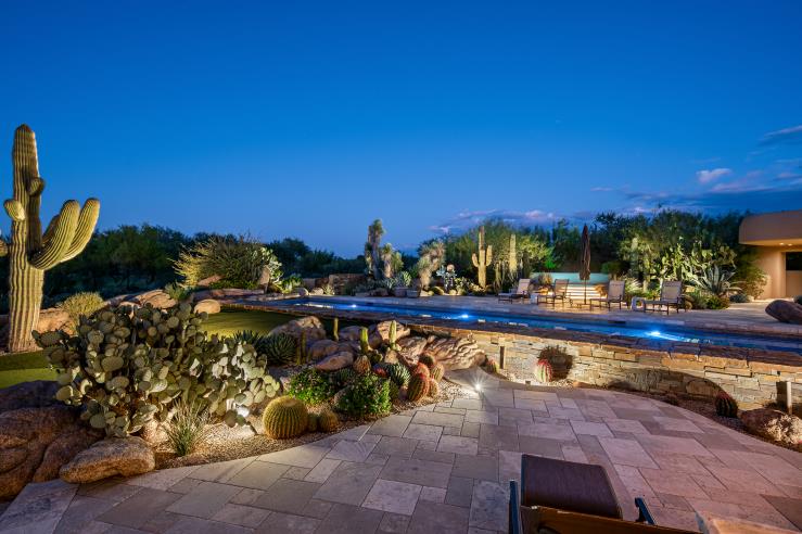 The illuminated pool and surrounding gardens beneath the evening sky.