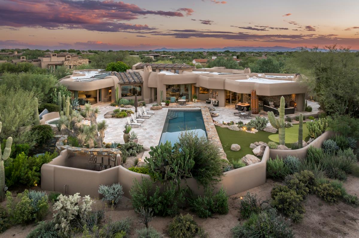 An elevated view toward the residence, lap pool and terraces at sunset.